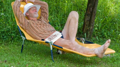Mähfreier Mai: Ein älterer Mann liegt entspannt auf einer Sonnenliege im Garten.